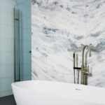 Freestanding bathtub with marble wall