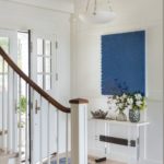 White entryway with blue painting Shingle-style home