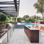 The full outdoor kitchen and bar are situated centrally for an ideal view of the pool.
