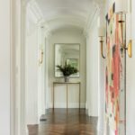Hallway with sconces and are collection on the walls