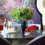 Dining table with zinc top and bold painting in the background