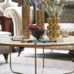 A detail shot of a brass coffee table adored with brass vases.