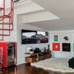 Julian Edelman's Game room with dark wood floors, a red spiral staircase and a small Coke machine.