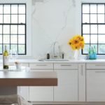 An up-close view of the white kitchen cabinets and marble backsplash
