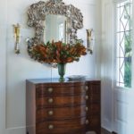 Entryway with chest topped with an arrangement of brown and green leaves