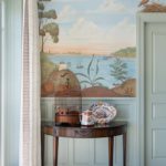 Detail of side table and mural featuring boats on the water