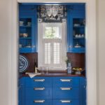 bight blue cabinets with a white shuttered window
