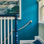 blue shiplap wall behind the blue railing of a staircase