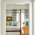 master bedroom with dark wood canopy bed and pale green shiplap walls