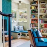 bookshelves, window seat and fireplace clad in blue tile