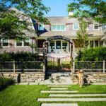 Shingle style home with arbor designed by Hutker Architects