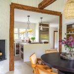 Kitchen and dining area with white walls and rustic beams
