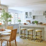 Neutral kitchen with brass bar stools and rattan chairs