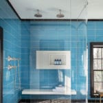 Shower with glass door and bright blue tile