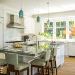 Cape Cod kitchen with white cabinets and teal pendant lights.
