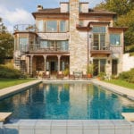 Three story shingle style home with a pool.