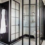 Primary bath with black and white palette and a metal shower door.
