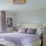 Primary bedroom with lavender drapes and bedding.