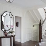 White entryway with demi-lune console.