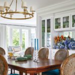 Traditional dining room with brass chandelier and seats upholstered in peacock blue