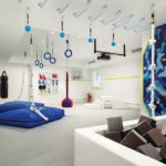 Children's playroom designed with trapeze, mats, and foam block pit.