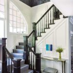 Entryway with white trim and black railing