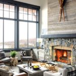 Vermont cabin with large windows and stone fireplace.