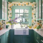 Pantry with bold wallpaper and green cabinetry
