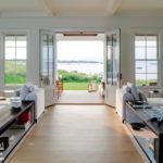 Two large doors of a Nantucket home open to the water