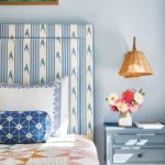 Blue and white patterned headboard with rattan reading lamps