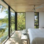 Bedroom with large windows overlooking a lake