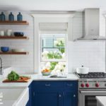 Blue and white kitchen with floating wood shelves