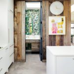 Wall clad in reclaimed wood and a powder room with bold wallpaper.
