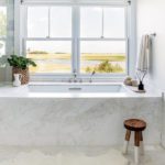 Large marble bath in front of a window