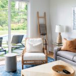 Sitting area with neutral upholstery and a blue rug.