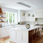 All white kitchen with floating wood shelves.