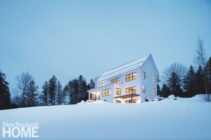 Modern farmhouse on a snowy hill.