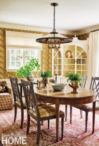 Dining room with brown patterned wallpaper.