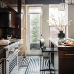 Art deco inspired kitchen with glossy brown cabinets and black and white floor.