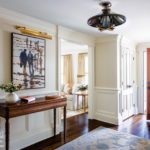 Entryway with white walls and a painting by Olivier Suire Verley