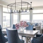 Dining area with blue upholstered and bronze light fixture.