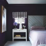 Bedroom with dark walls and a roman shade with a graphic pattern