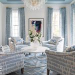 Light blue and white room with four chairs around a coffee table