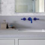 Bath vanity with bright blue faucet and taps