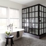 Bathroom with a large shower with black metal and glass grid enclosure.