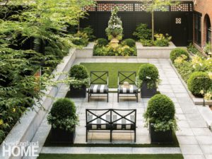 Formal Boston garden with large urns and wrought iron furniture