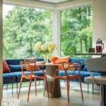 Large L-shaped banquette with blue upholstery and orange chairs.