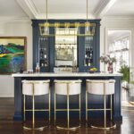 Home lounge with blue cabinetry and white and gold stools