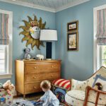 Boy's room with blue walls and star patterned wallpaper on the ceiling.