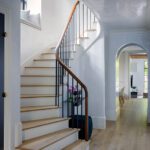 Entryway to a Cambridge home with a light wood floors and curved staircase